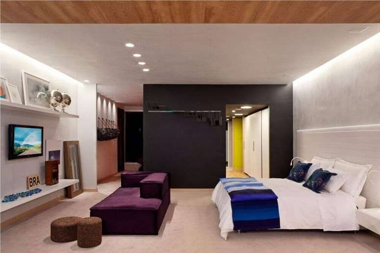 27. Decoração moderna com sofá roxo e parede preta para quarto com closet – Foto: Juliana Santana