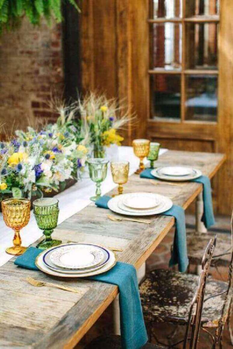 41- Na mesa posta rústica os talheres são dourados e as taças coloridas. Fonte: Style Me Pretty