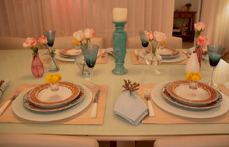 65- Na mesa posta para jantar tem pequenas taças com flores sobre os pratos. Fonte: Sua Casa Sua Festa