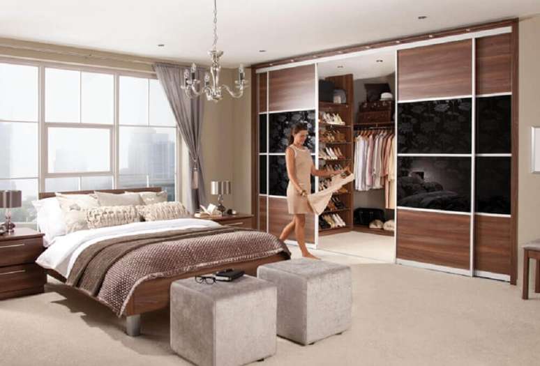 53. Modelo de quarto de casal com closet decorado com pendente sobre a cama e portas de correr – Foto: Yandex