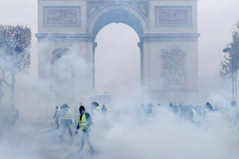 Manifestantes com coletes amarelos protestem em frente ao Arco do Triunfo, em Paris, em meio a bombas de gás lacrimogêneo 01/12/2018 REUTERS/Stephane Mahe