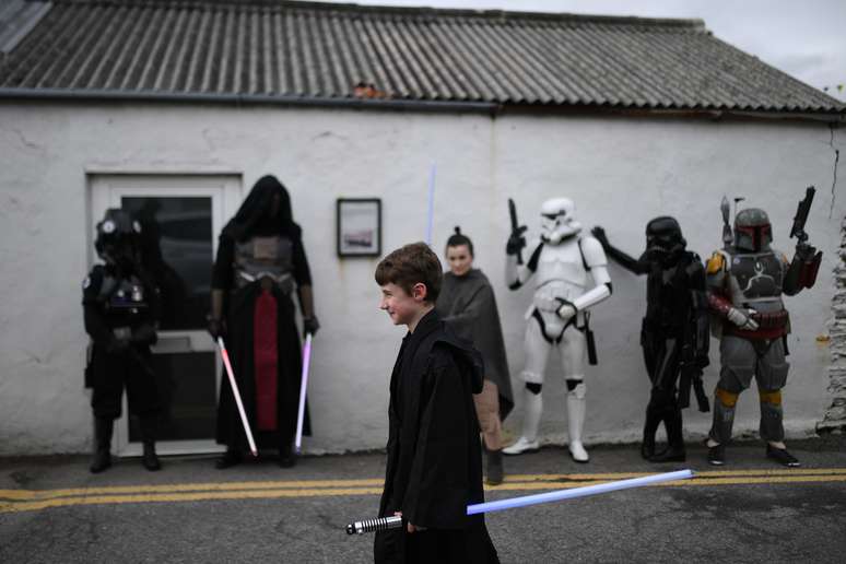 Menino com sabre de luz passa por grupos de f&atilde;s vestidos com ropuas de "Star Wars" 04/05/2018 REUTERS/Clodagh Kilcoyne
