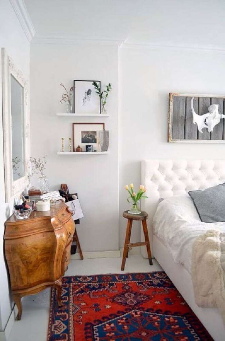 26. Decoração com tapete para quarto de casal com cabeceira branca capitonê e cômoda antiga de madeira – Foto: Pinterest