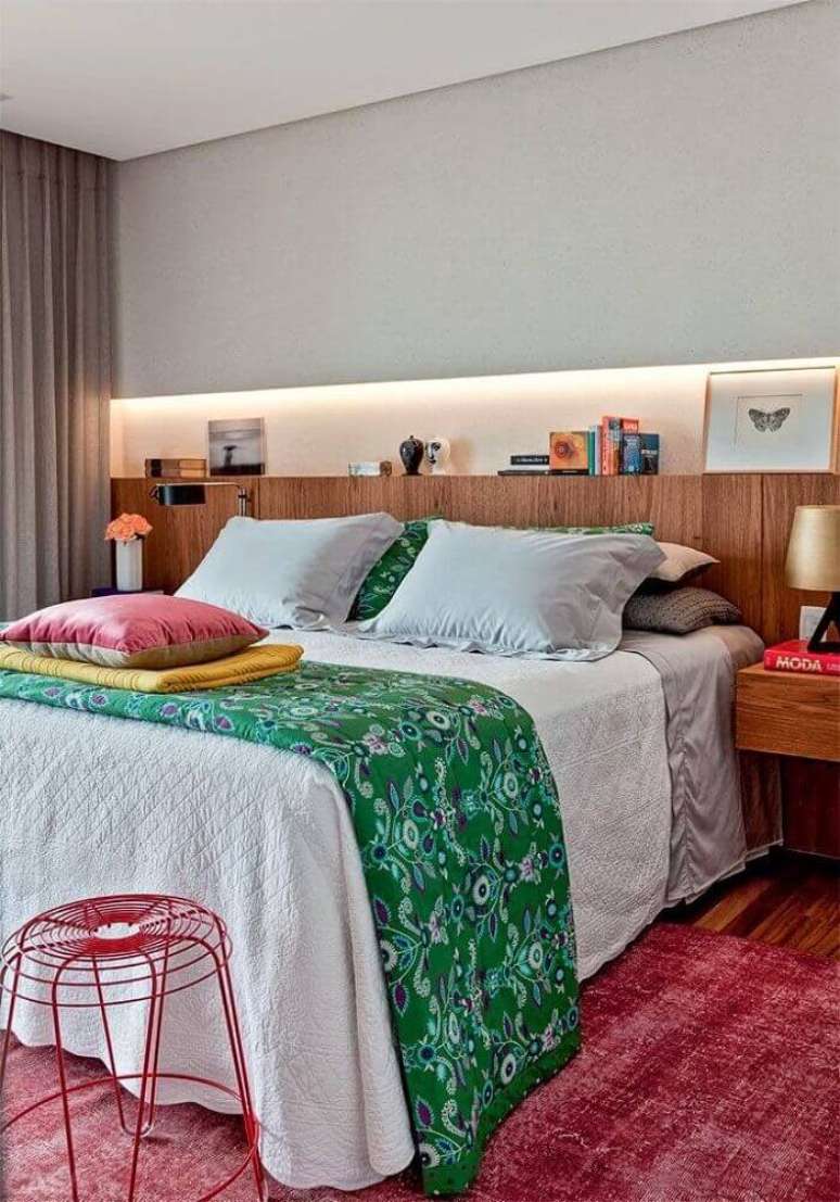 27. Decoração com tapete para quarto de casal com cabeceira e criado mudo de madeira – Foto: Webcomunica