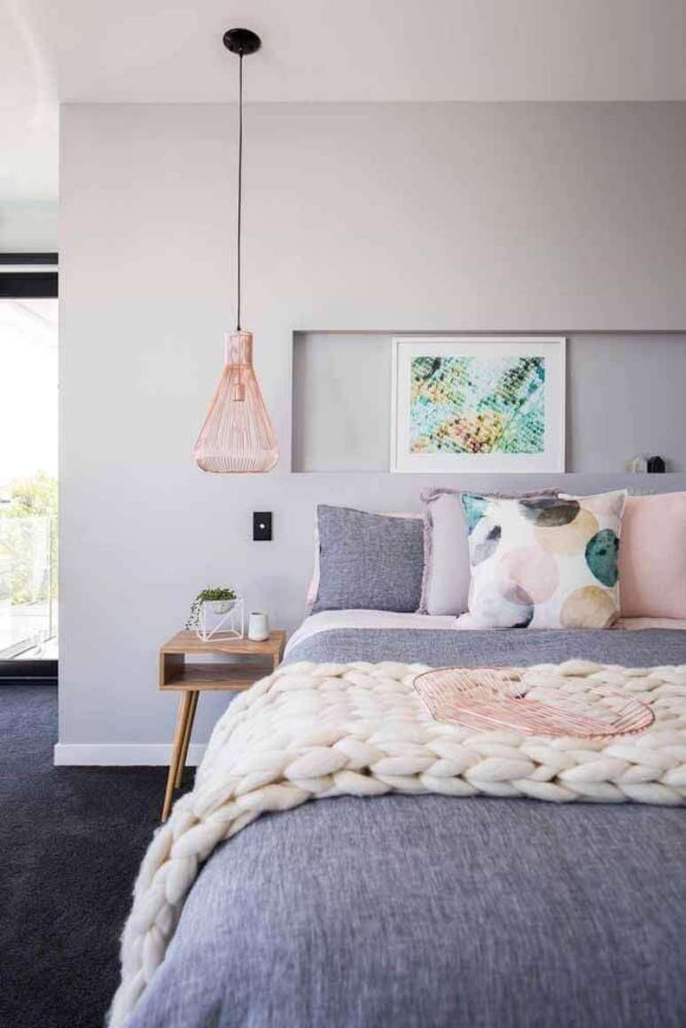 33. Decoração minimalista para quarto rose gold com luminária moderna ao lado da cama – Foto: Pluska