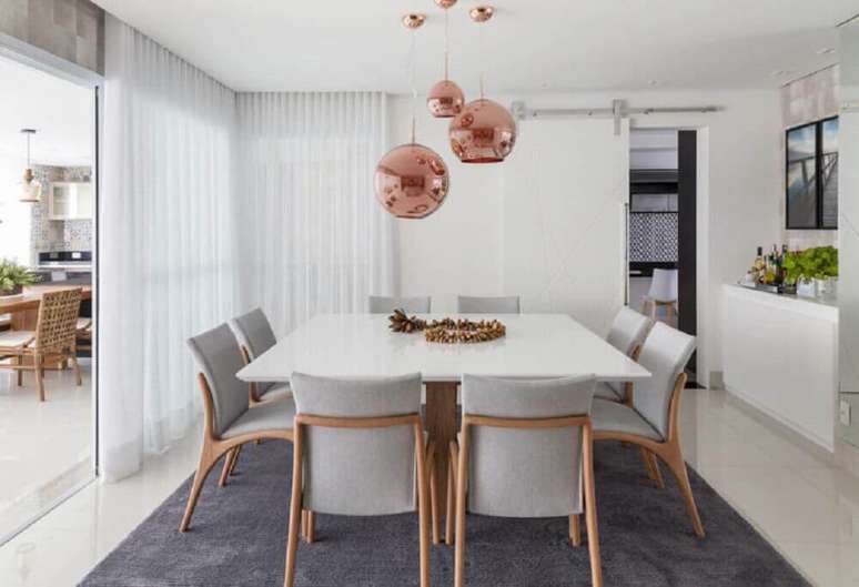 50. Decoração rose gold sala de jantar com mesa quadrada toda branca e pendentes redondos – Foto: Foto Érica Salguero