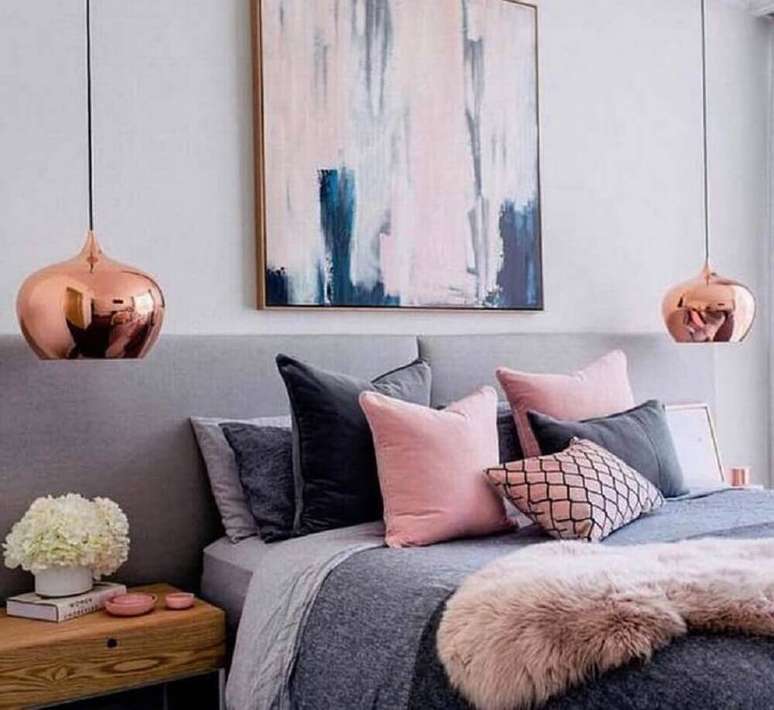 66. Decoração para quarto rose gold e cinza com grande quadro na cabeceira e pendentes nas laterais da cama – Foto: FirePont