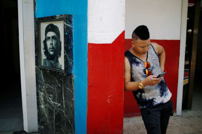Jovem verifica celular em Cuba perto de um hotspot de internet 10,/8/2018 REUTERS/Tomas Bravo 