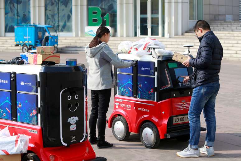 Pessoas retiram encomendas de robô de entregas autônomo da JD.com em Tianjin, China
12/11/2018 REUTERS/Stringer