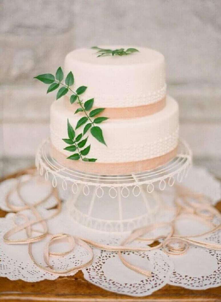 16. Decoração com bolo de casamento simples decorado com pequenas folhagens e detalhes em salmão – Foto: Weddywood