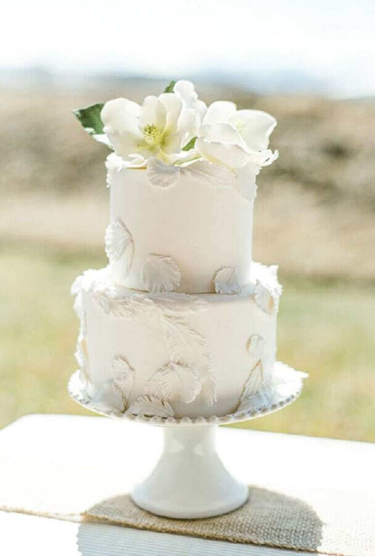 18. Bolo de casamento simples e bonito 2 andares e todo branco decorado com flores brancas no topo – Foto: Decobake