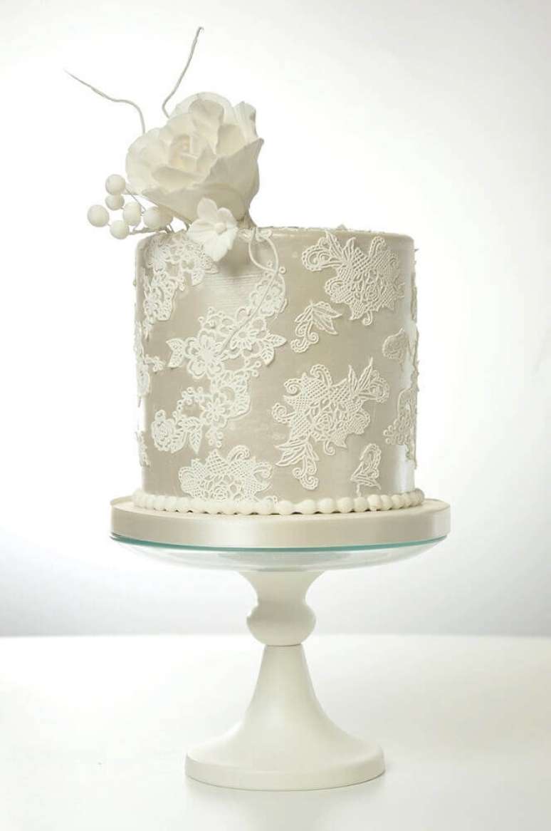 20. Modelo clássico de bolo de casamento simples e bonito decorado todo branco com rendas e flor branca no topo – Foto: Love Crear