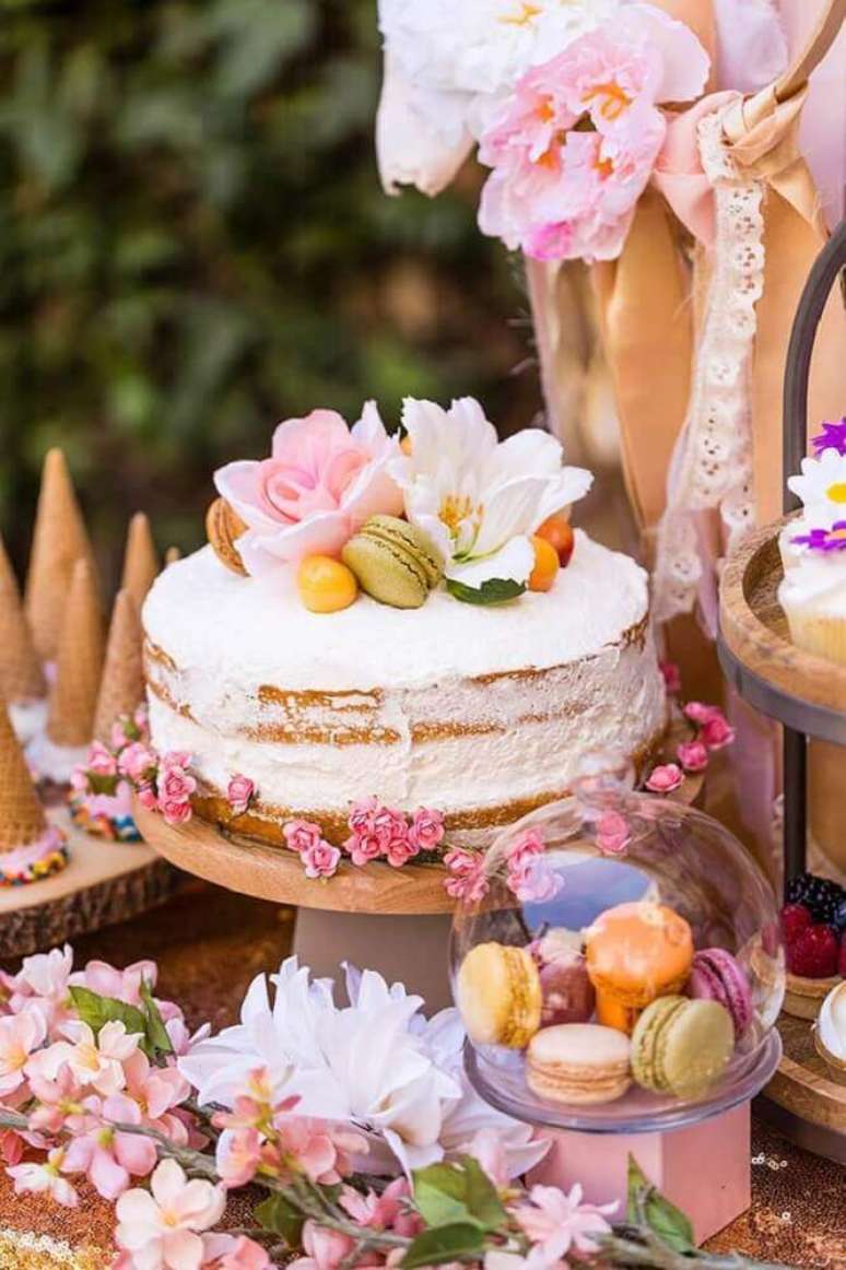 44. Decoração romântica com bolo de casamento simples com chantilly e flores – Foto: Brit + Co