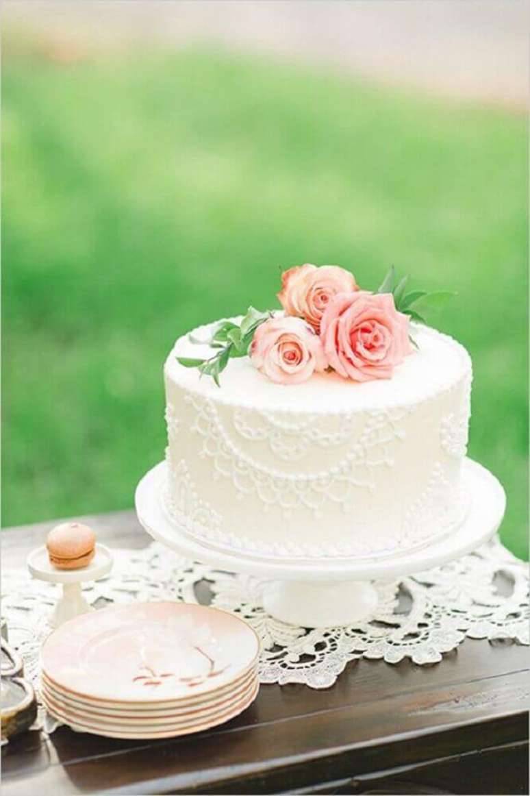 51. Uma decoração clássica com bolo de casamento simples e bonito deve conter flores e rendas – Foto: Leeches