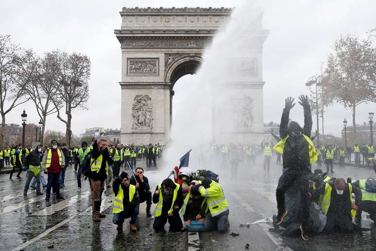 Manifestantes de coletes amarelos são atingidos por jato d'água da polícia perto do Arco do Triunfo, em Paris
01/12/2018
REUTERS/Stephane Mahe