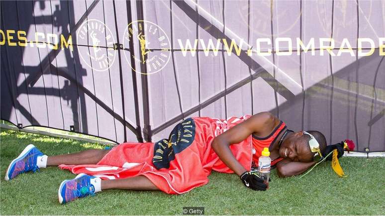 Um corredor no chão depois de terminar a Comrades Marathon, de 89,2 km, na África do Sul, uma das ultramaratonas mais cansativas do mundo