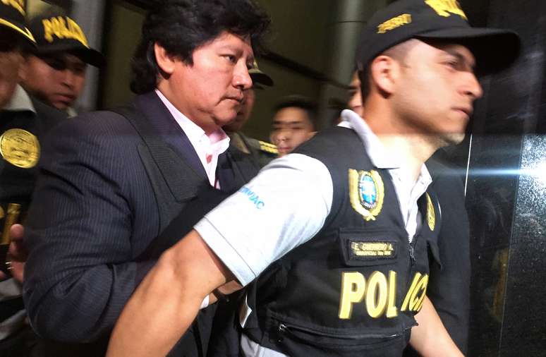 Policial leva Edwin Oviedo, presidente da Federação Peruana de Futebol