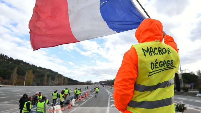 Manifestante veste colete amarelo com os dizeres 'Macron cai fora'