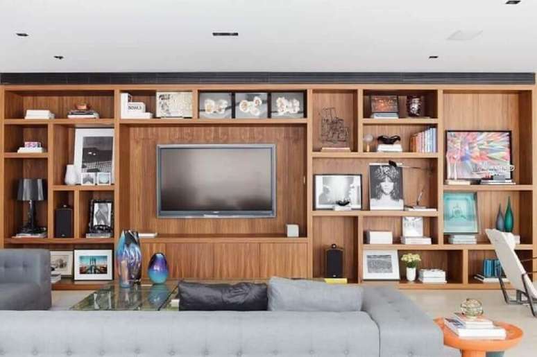 25. Enfeites decorativos par sala com grande estante de madeira – Foto: Suite Arquitetos