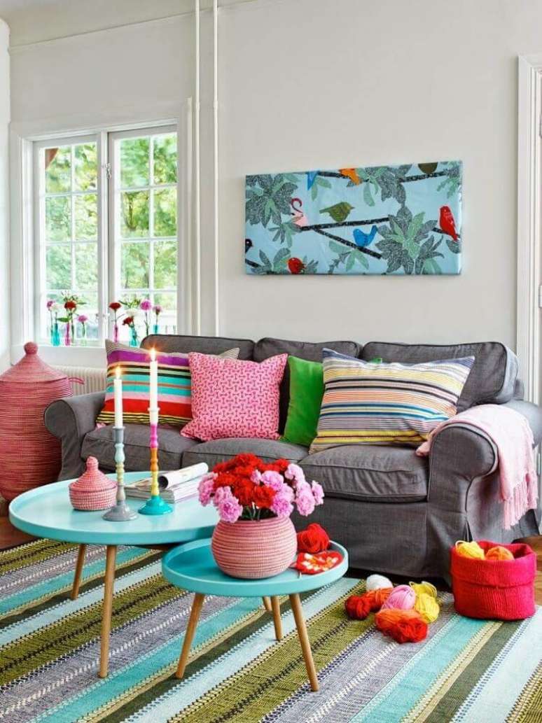 27. Decoração colorida com tapete listrado e objetos decorativos para sala com sofá cinza – Foto: Hum Ideas