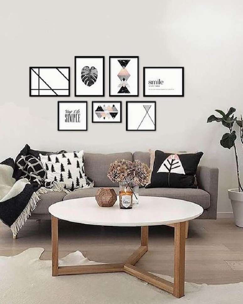 59. Objetos decorativos para sala minimalista com quadros na parede e manta preta no sofá – Foto: Casa e Festa