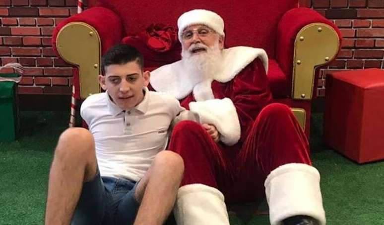 O Papai Noel João Prim ao lado do jovem Vitor.