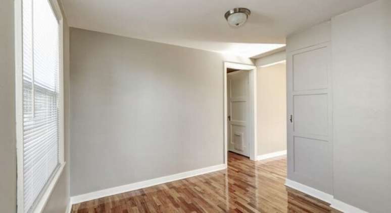 14- O rodap&eacute; de madeira pintado de branco contrasta com a cor cinza das paredes. Fonte: GrupoFort Decor