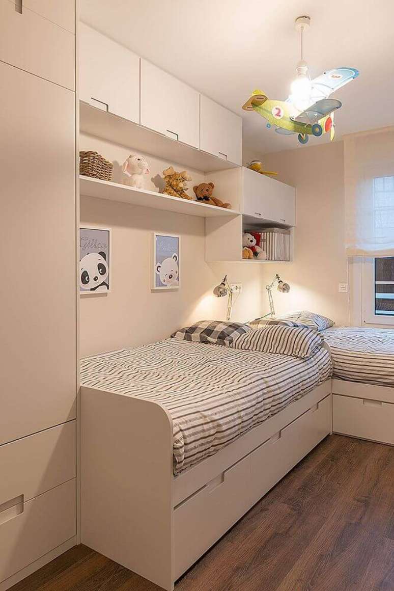 24. Decoração toda branca para quarto de solteiro planejado com duas camas e aviãozinho no teto completando a decoração – Foto: Pinterest
