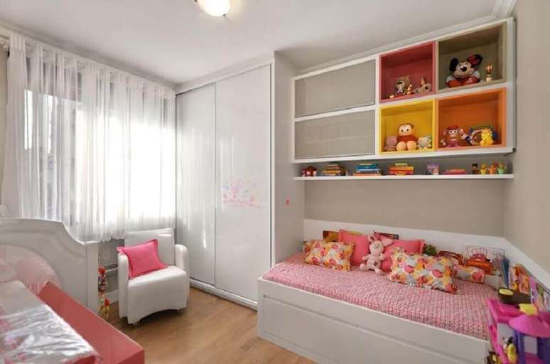 39. Decoração para quarto de solteiro planejado infantil com nichos coloridos e poltrona branca – Foto: Andreza Goulart