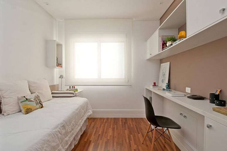 41. Móveis planejados para quarto de solteiro simples com piso de madeira e cadeira Eames preta – Foto: Patricia Kolanian Pasquini