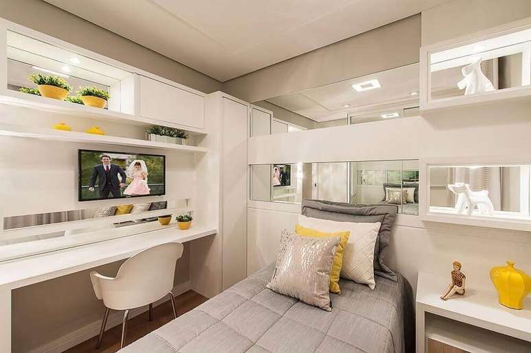 42. Móveis planejados para quarto de solteiro todo branco com nichos espelhados e iluminação embutida – Foto: Webcomunica