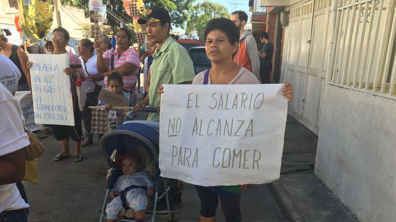 Venezuelanos protestam por conta da pobreza no pa&iacute;s com cartazes dizendo que o sal&aacute;rio n&atilde;o lhes permite comer e que n&atilde;o h&aacute; luz, &aacute;gua e/ou g&aacute;s