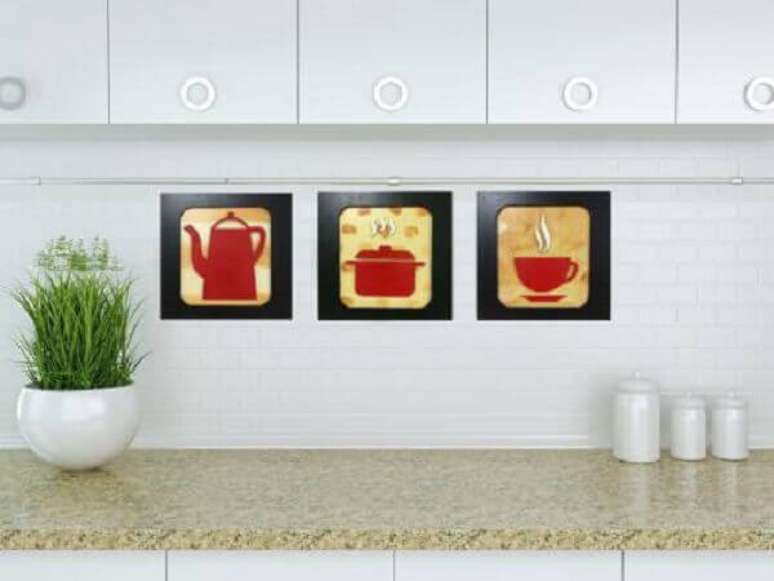 16- Os três quadrinhos para cozinha tem molduras pretas, quadradas e figuras vermelhas para contrastar com o ambiente branco. Fonte: Decoração de Casa