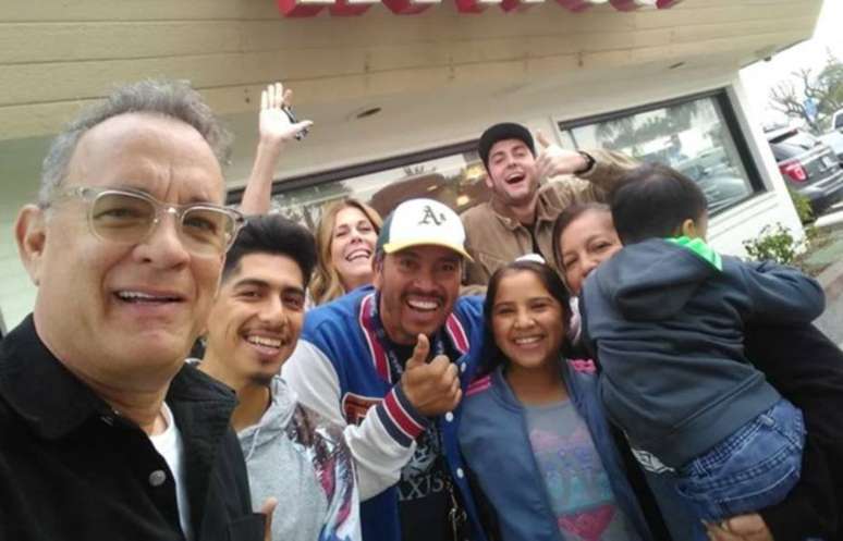 Tom Hanks ao lado de seus fãs que tiveram refeições pagas por ele.