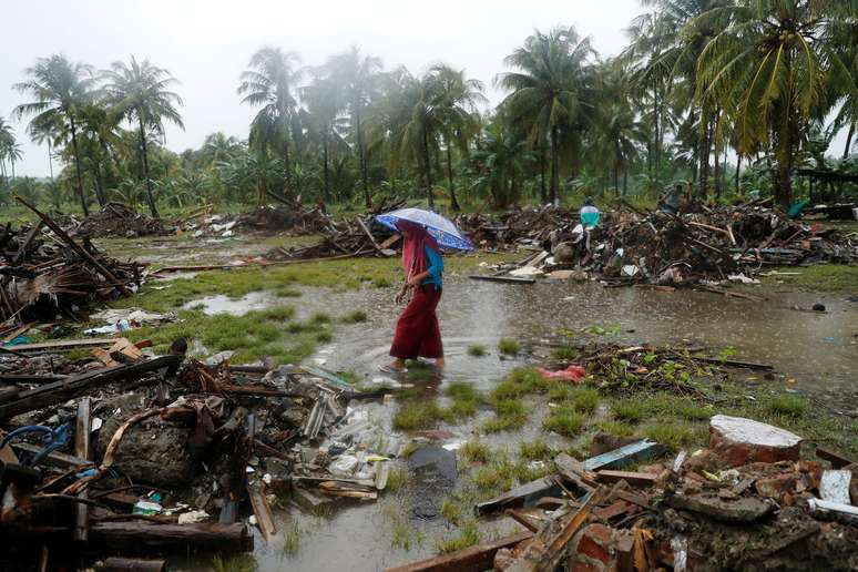 Mulher anda entre os escombros deixados pelo tsunami na Indonésia