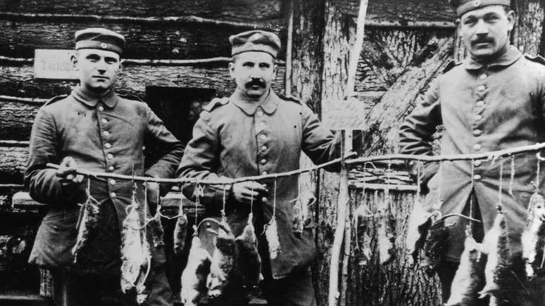 Homens mostram ratos capturados na Primeira Guerra Mundial; cientistas criticam conduta de 'guerra' contra os roedores