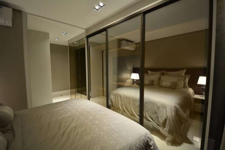 31. Arm&aacute;rio de quarto de casal com portas espelhadas em frente &agrave; cama. Projeto de Maira Ritter