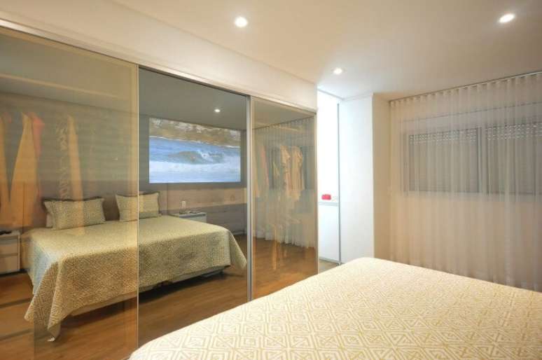 29. Arm&aacute;rio de quarto de casal com portas de vidro bronze. Projeto de Condecorar