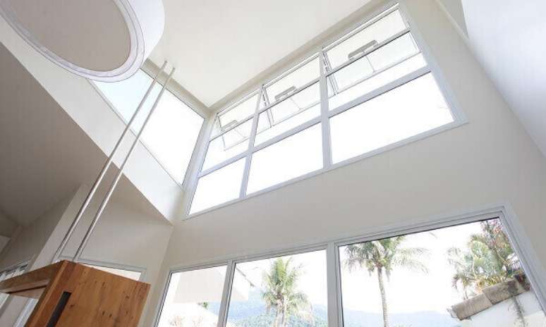 34- As esquadrias superiores na resid&ecirc;ncia de p&eacute; direito duplo decoram a sala. Fonte: Jmar Esquadrias