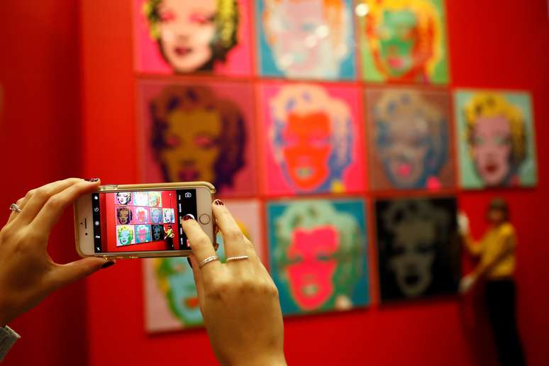 Mulher tira foto com celular de telas de Marilyn Monroe em exposi&ccedil;&atilde;o de Andy Warhol em Londres 10/02/2017 REUTERS/Stefan Wermuth