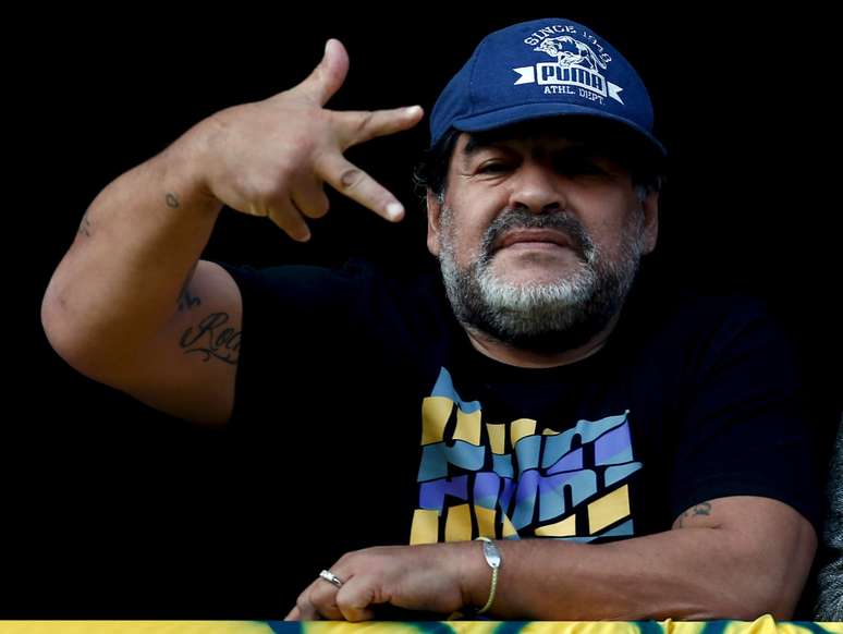 Ex-jogador Maradona acena durante partida de futebol no estádio La Bombonera, em Buenos Aires