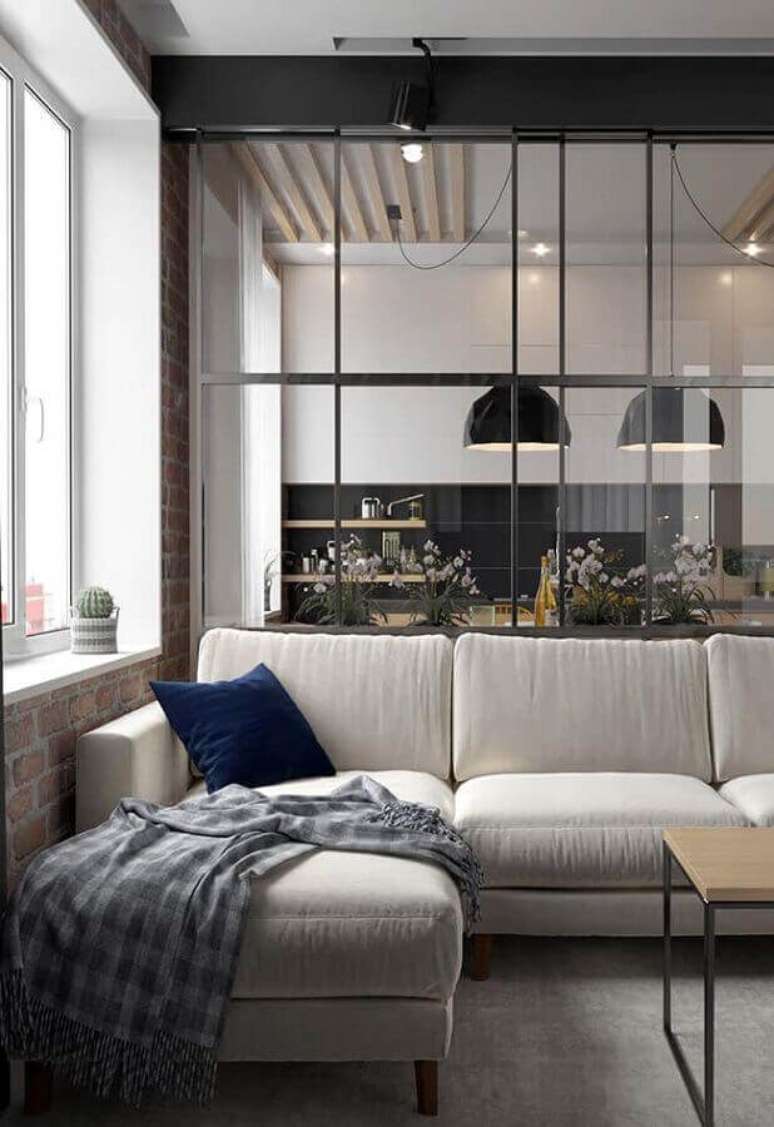 8. Decoração com estilo industrial para sala com manta para sofá de canto com chaise e parede de vidro ao fundo – Foto: Pinterest