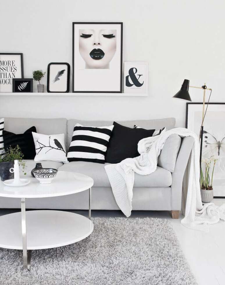 37. Decoração em preto e branco para sala de estar com muitos quadros, almofadas e manta para sofá – Foto: We Heart It