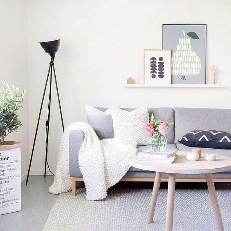 38. Sala de estar minimalista decorada com luminária de chão, mesa redonda de madeira e manta para sofá – Foto: Lovingit