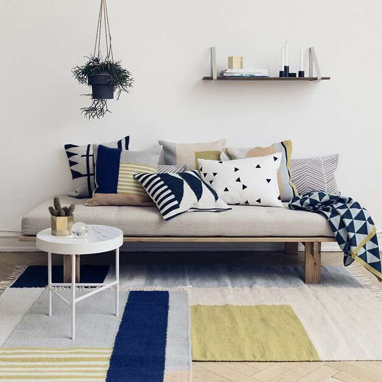 39. Decoração simples para sala minimalista com muitas almofadas e manta estampada para sofá pequeno – Foto: Royal Design