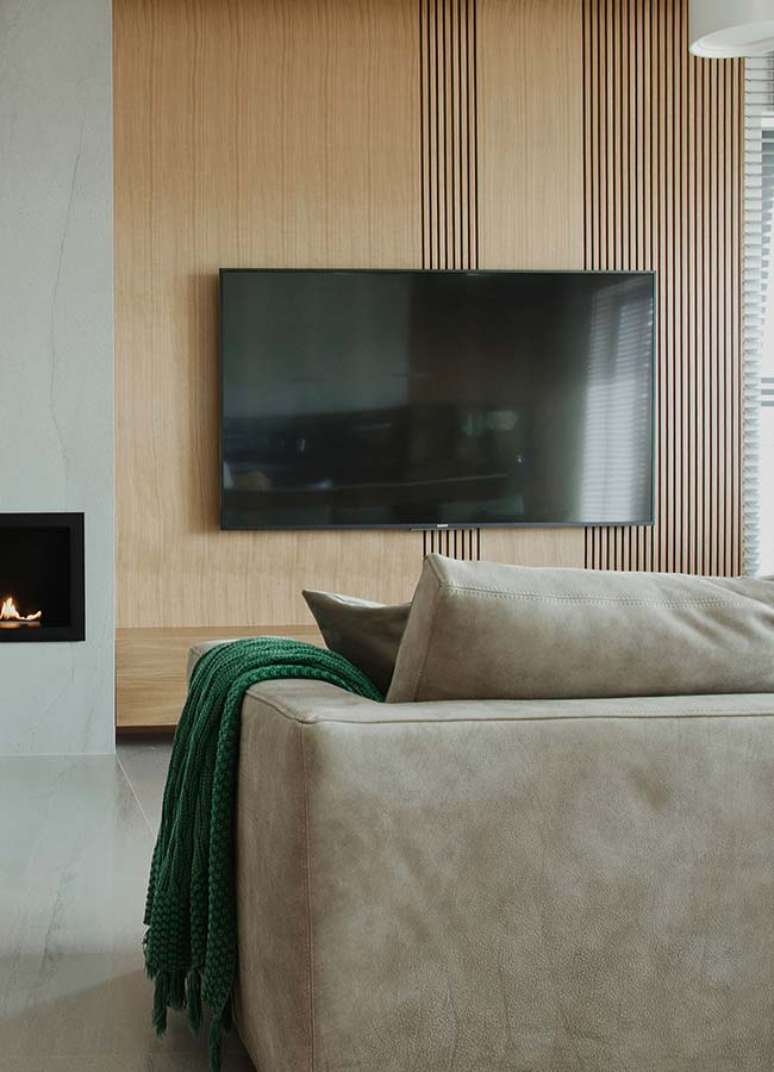 47. Decoração para sala com painel de madeira e manta verde para sofá – Foto: Pinterest