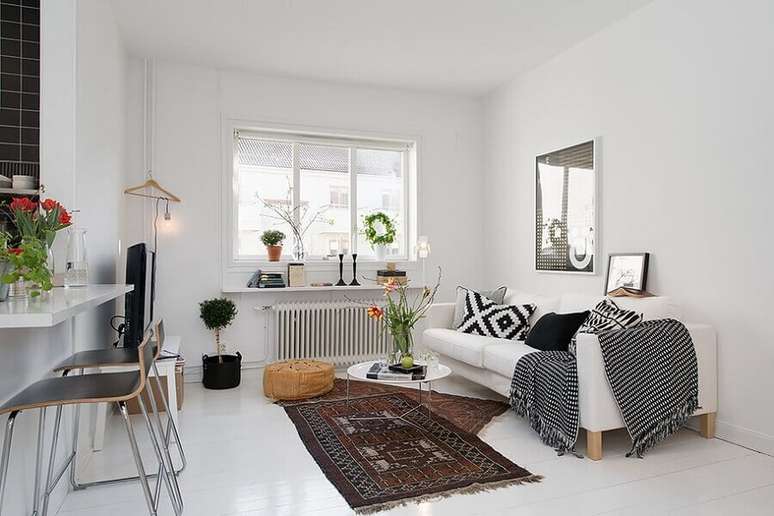 51. Decoração simples para sala com mesa de centro redonda e manta para sofá branco – Foto: Teklic