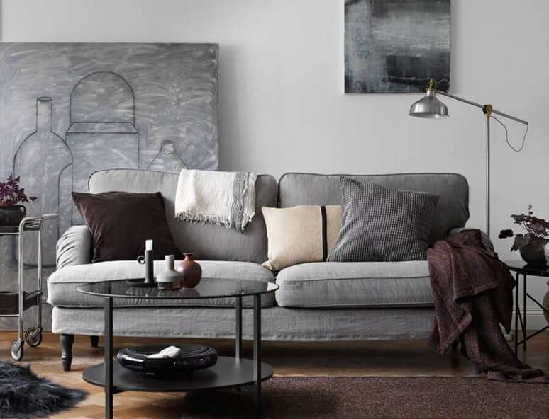 60. Decoração moderna para sala em tons de cizna com grande quadro apoiado na parede e mantas para sofá – Foto: IProperty