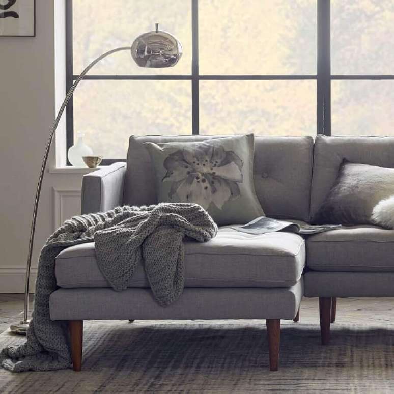 82. Decoração em tons de cinza para sala com luminária de chão e manta de crochê para sofá grande – Foto: West Elm