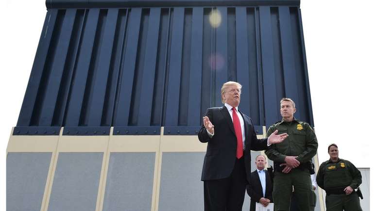 Trump ao lado de um possível protótipo de muro para a fronteira; orçamento da obra causa um impasse no governo americano